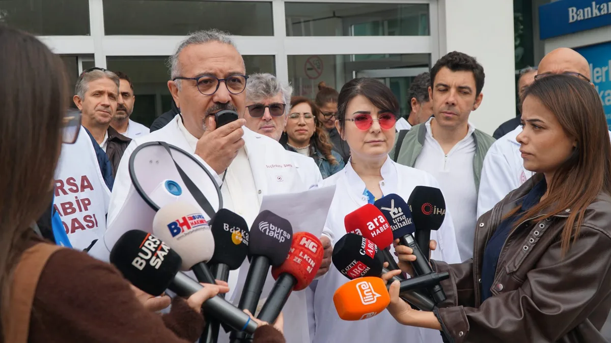 Özel Nev Esentepe Hastanesi önünde mikrofonlar karşısında basın açıklamasını okuyan beyaz önlüklü bir hekim; çevresinde Bursa Tabip Odası yelekli hekimler ve gazeteciler.