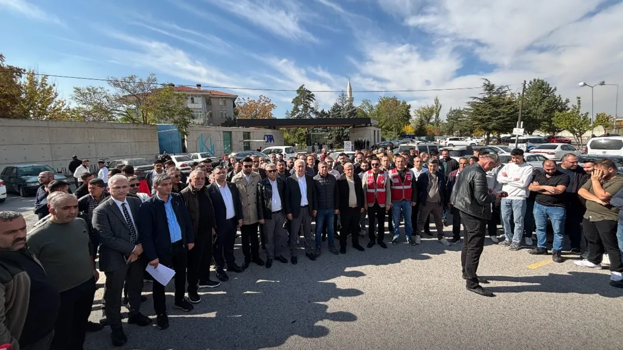 Kayseri'de Orta Anadolu fabrikasının önündeki açık alanda, aralarında kırmızı yelekli kişilerin de bulunduğu kalabalık bir işçi grubu güneşli bir günde basın açıklaması için toplanmış.
